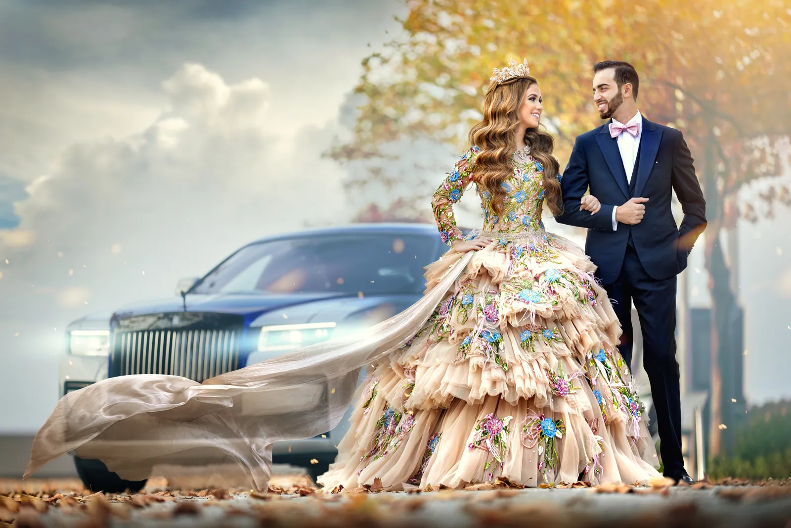 Couple in front of a Rolls-Royce, bride in a floral ballgown with a long veil