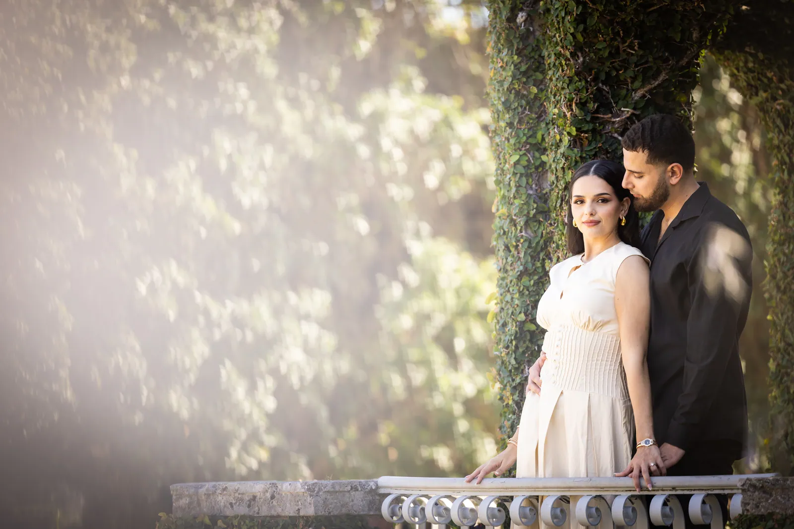 Couple under the trees in a garden, bride in an ivory gown