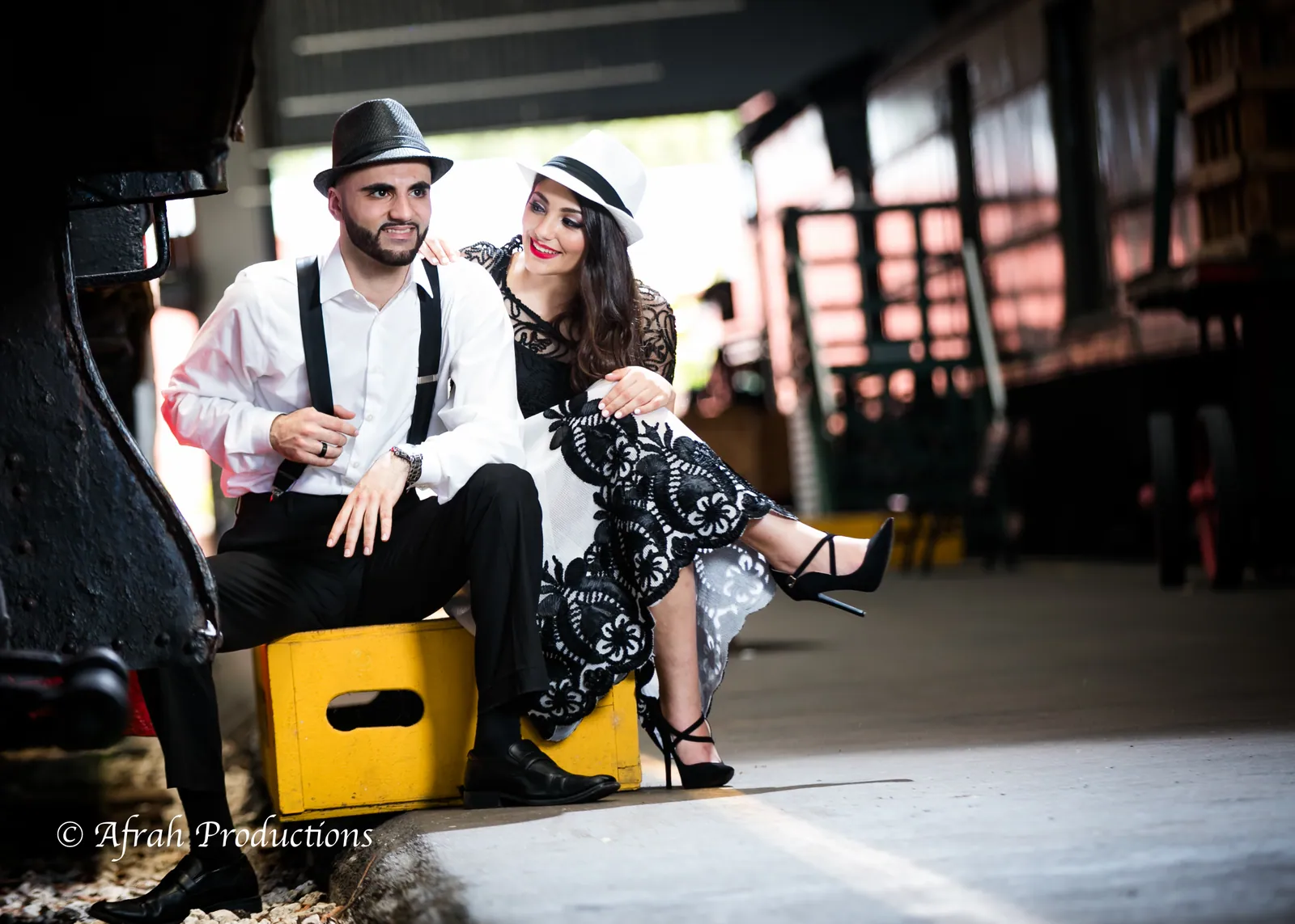 Couple seated in the train yard, vintage styling